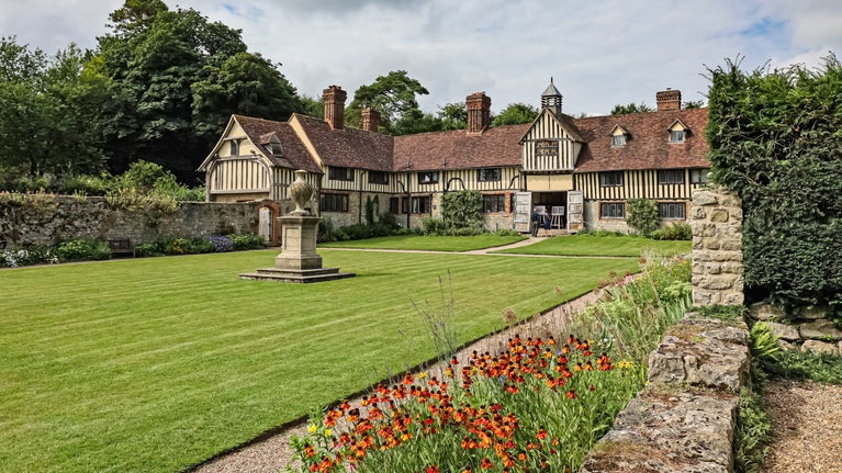 Late summer view of lawn and fifteenth-century cottages at Ightham Mote, Kent